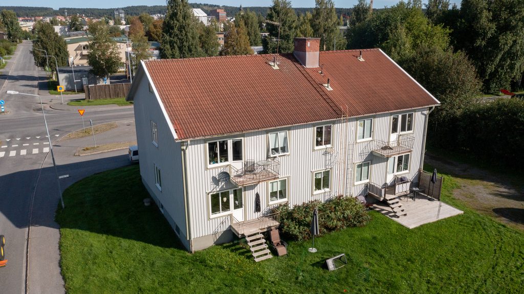 Ett vitt lägenhetshus på Plangatan 5 i Skellefteå, under sommaren
